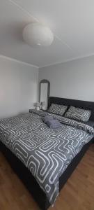 a bed with a black and white comforter and pillows at Istabiņa Carnikavā in Carnikava
