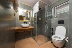 un bagno con wc e doccia in vetro di Cedar Hill Lodge - A Boutique Homestay a Mashobra Altre 37 foto