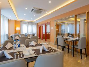 a restaurant with tables and chairs and a large mirror at Naksel Urban Hotel & Spa in Thimphu