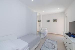 Habitación blanca con 2 camas y TV. en Familiy Villa Navis with heated pool, en Rogotin