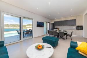 Una sala de estar con cocina y comedor. en Familiy Villa Navis with heated pool, en Rogotin