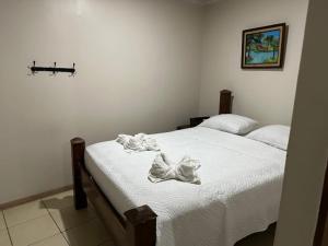 a bedroom with a bed with white sheets on it at Rivera Family Airport Apartments in Santiago Este