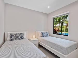 due letti in una stanza bianca con una finestra di Amazing Family Home in Hollywood FL a Hollywood Altre 15 foto