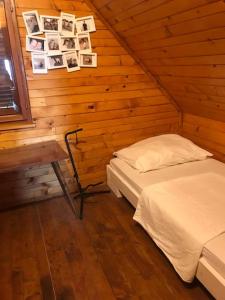 a bedroom with two beds and a table and pictures on the wall at Cozy vacation house in Gabrovka