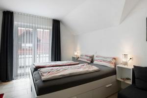 a bedroom with two beds and a large window at Appartement Mia in Ihrlerstein