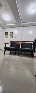 two black benches in a room with pictures on the wall at Humble house in Anan-nam