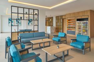 a waiting room with blue chairs and tables at Fairfield by Marriott Kuala Besut in Kuala Besut