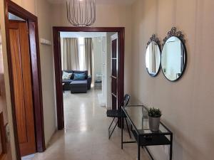 a living room with a glass table and mirrors at Perla en el Corazón de Málaga in Málaga +27 photos