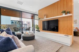 a living room with a large flat screen tv at Harbour front Living at Wynyard Marina in Auckland