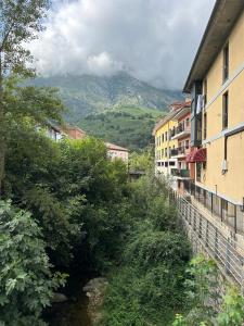 a river in a town with a mountain in the background at La Ventana y el Ciervu in Arenas de Cabrales +11 photos