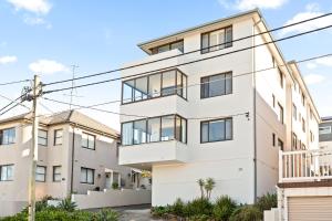 シドニーにあるPristine 2-Bed With Expansive Beach Viewsの白いアパートメントビルの外観