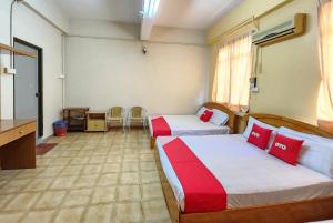 a hotel room with two beds and a desk at Hotel O Ban Cheong in Kangar