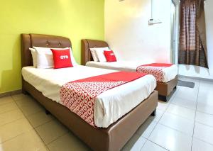 a room with two beds with red and white sheets at Hotel O Ban Cheong in Kangar