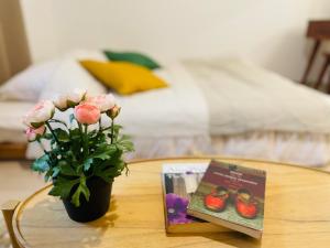 una mesa con un jarrón de flores y un libro en Sweet Breeze Stay Guesthouse, en Seúl