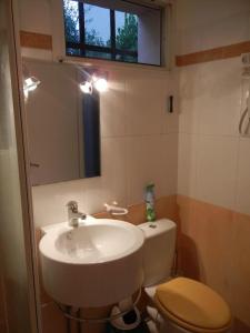Un baño con lavabo, inodoro y ventana. en Pt prixappart au calme vue mer, en Bandol