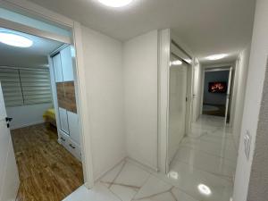 a hallway with white walls and a walk in shower at JB apartman Živinice in Živinice