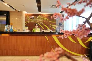 two people sitting at a bar in a restaurant at Bonnet Hotel Surabaya in Surabaya