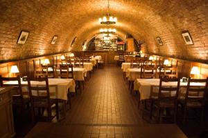 a restaurant with tables and chairs in a tunnel at Adler Panzio in Budaörs