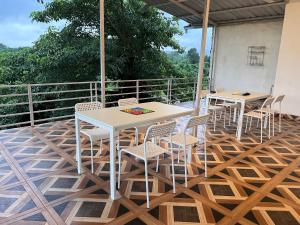 a patio with tables and chairs on a deck at Mikunj Farms Karjat in Karjat