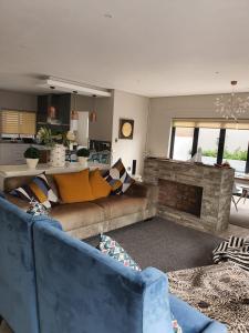 Luxury holiday home 3 bedroom, 3 bathroom house in Nahoon في شرق لندن: غرفة معيشة مع أريكة ومدفأة