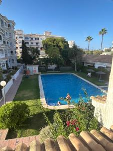 a person swimming in a swimming pool in a yard at Encanto Mediterráneo Apartamento Céntrico a Pasos de la Playa del Albir in Albir