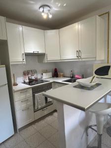 a kitchen with white cabinets and a white counter top at Encanto Mediterráneo Apartamento Céntrico a Pasos de la Playa del Albir in Albir +3 photos