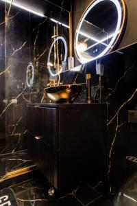 a black bathroom with a sink and a mirror at Desire Loft in Alba Iulia