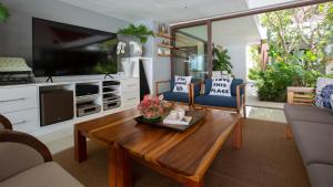un salon avec une table basse et une télévision dans l'établissement Chic Baan Capo - Luxury Four Bedroom Beachfront Villa, à Bangrak Beach