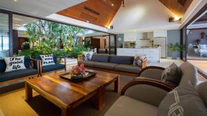 un salon avec un canapé et une table dans l'établissement Chic Baan Capo - Luxury Four Bedroom Beachfront Villa, à Bangrak Beach