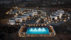 una vista aérea de un hotel con piscina por la noche en Thronos Suites, en Ano Mera