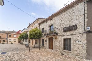 an old stone building on a cobblestone street at La Herrería in Canalejas de Peñafiel