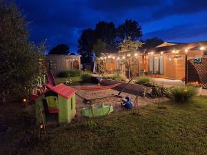 a backyard at night with a play set and a house at Park Jesionów domki - Pleśna in Pleśna