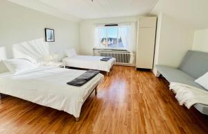 a bedroom with two beds and a couch and a window at CozyHouse in Halmstad
