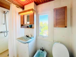 a bathroom with a sink and a toilet and a window at CozyHouse in Halmstad