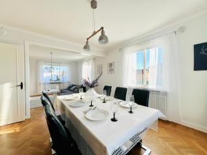 a dining room with a white table and chairs at CozyHouse in Halmstad