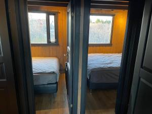 a small room with two beds and two windows at Cozy 3BR Summerhouse with Hot Tub in South Iceland in Selfoss