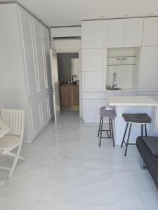 a kitchen with white cabinets and a table and chairs at Suite haussman casher in Netanya