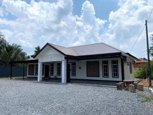 a small white building with a roof at Delima Guesthouse 2 bedroom,1 toilet in Changlun