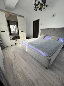 a bedroom with a large bed and a wooden floor at Jules Cozy Place in Bucharest