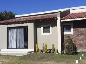 a small house with a window and two bushes at Serene Pastures in Midrand