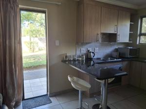 a kitchen with a counter and a stove and a window at Serene Pastures in Midrand