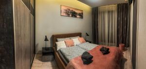 a bedroom with a bed with two black objects on it at Apartament Lux Gdańsk Nowa Motława in Gdańsk +12 photos