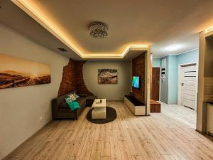 a living room with a couch and a tv at Apartament Lux Gdańsk Nowa Motława in Gdańsk