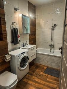 a bathroom with a washing machine and a toilet at Apartament Lux Gdańsk Nowa Motława in Gdańsk
