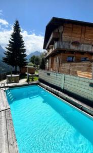 a large blue swimming pool next to a building at Hotel Almhof in San Candido