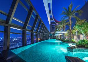una piscina nel mezzo di un edificio di notte di Caesar Park Hotel Banqiao a Taipei