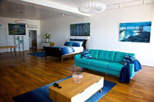 a living room with a blue couch and a bed at Penguin Beachfront Apartments in Penguin