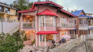 ein Haus mit roten Markisen in der Unterkunft SaffronStays Cottage Aaraish in Mukteswar