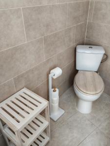 un bagno con un water e uno sgabello di legno di Casa Saucejo a El Saucejo Altre 20 foto