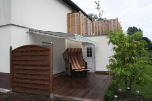 una terrazza in legno con una sedia su una casa di FeWo Alt Bukow nahe Ostseebad Rerik ad Alt Bukow